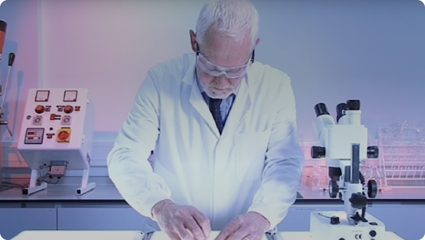 Un hombre con bata de laboratorio mirando una tableta