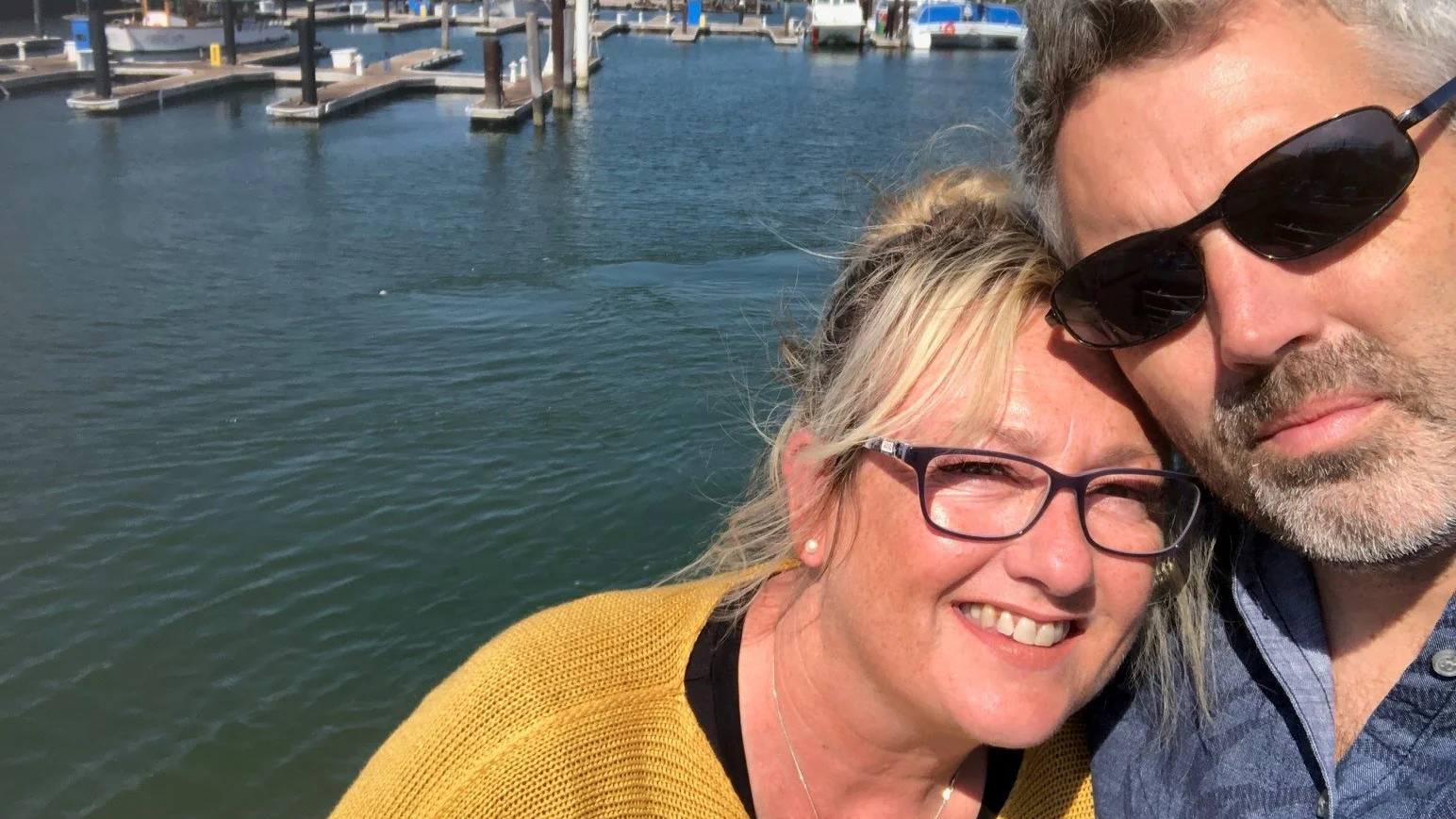 un uomo e una donna che scattano un selfie in riva all'acqua